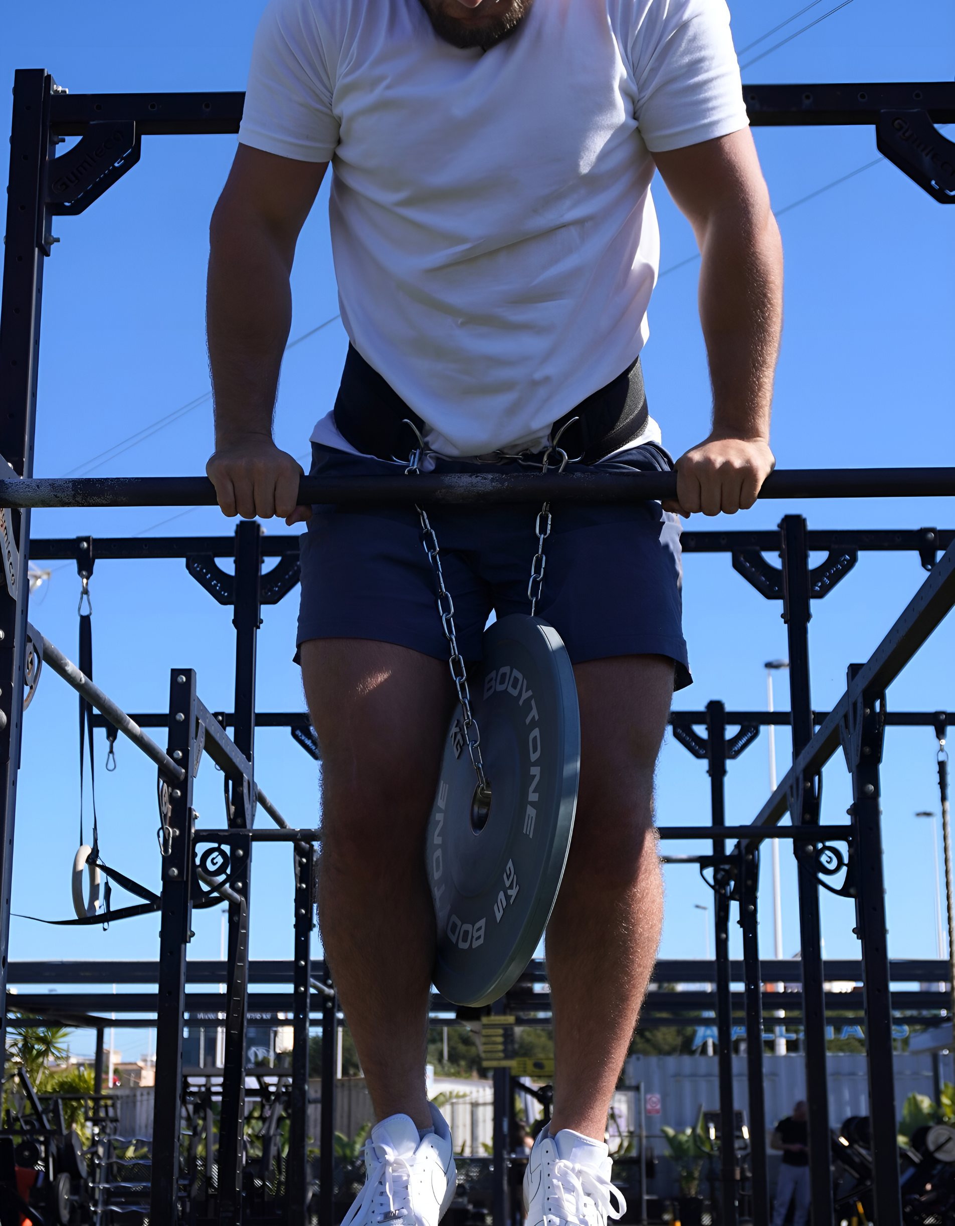 Ceinture lestée muscu xtremefit en utilisation pour un muscle-up. Idéal pour ajouter progressivement de la difficulté lors de mouvements de musculation tel que les dips ou tractions.