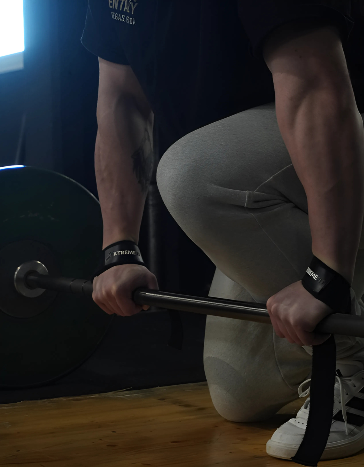 Athlète en salle de muscu avec des sangles de levage xtremefit noir idéal pour le powerlifting, le levage de charges et le bodybuilding